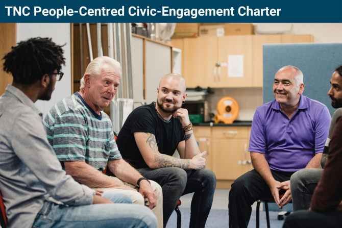 photo of five people of different ages sitting in a semi-circle having a discussion