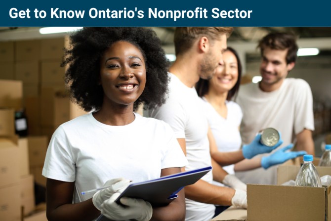 Photo of a woman holding a clipboard, looking at the camera and smiling. In the background, three people are talking while placing cans in a box.